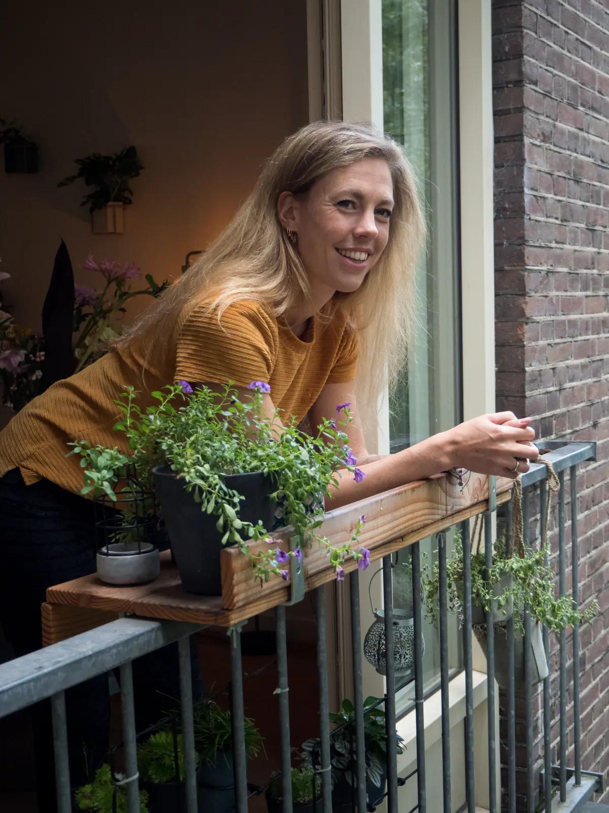 Anneke op haar balkon tussen de planten