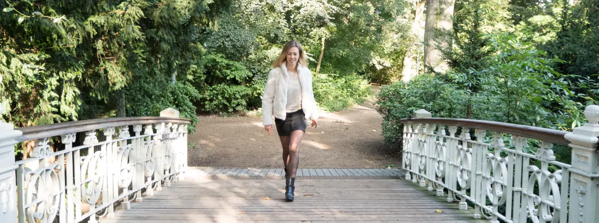 Anneke wandelt over een witte brug in het park